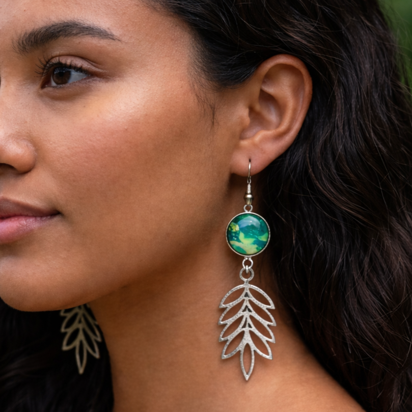 Close-up of a woman wearing a leaf-shaped earring with a colorful bead.